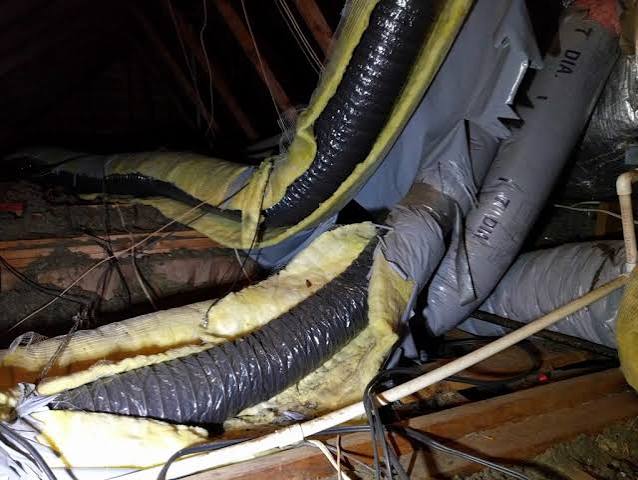 Deteriorating, sagging flexible HVAC ductwork with worn fiberglass insulation in a Raleigh-area attic